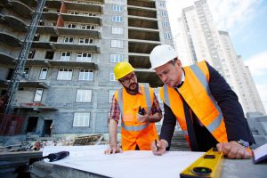 Osoby na budowie dyskutują o projekcie