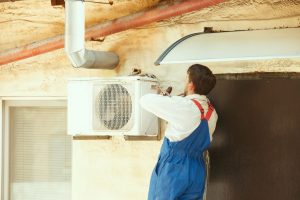 HVAC technician working on a capacitor part for condensing unit